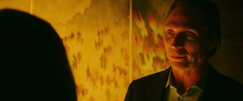 Movie still from “Teenage Mutant Ninja Turtles” (2014), directed by Jonathan Liebesman – A man standing in front of a painting of flames; Close Up shot, Over the shoulder angle