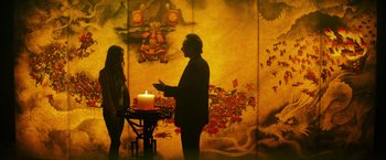 Movie still from “Teenage Mutant Ninja Turtles” (2014), directed by Jonathan Liebesman – A man standing in front of a wall with a lit candle; Medium shot, Over the shoulder angle