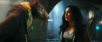 Movie still from “Teenage Mutant Ninja Turtles” (2014), directed by Jonathan Liebesman – A woman standing next to an animal in a room; Close Up shot, Over the shoulder angle