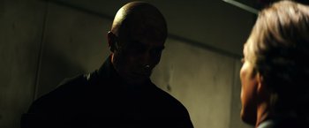 Movie still from “Teenage Mutant Ninja Turtles” (2014), directed by Jonathan Liebesman – A man with a bald head is standing in the dark; Close Up shot, Low angle