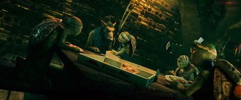 Movie still from “Teenage Mutant Ninja Turtles” (2014), directed by Jonathan Liebesman – A group of people sitting at a table eating pizza; Medium shot, High angle