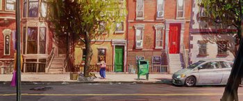 Movie still from “Teenage Mutant Ninja Turtles: Mutant Mayhem” (2023), directed by Jeff Rowe – A woman standing on the side of the road near a tree; Extreme Wide shot, High angle