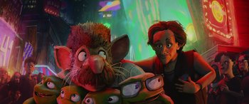 Movie still from “Teenage Mutant Ninja Turtles: Mutant Mayhem” (2023), directed by Jeff Rowe – A man and a woman are posing for a picture with a stuffed animal; Medium shot, Over the shoulder angle