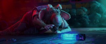 Movie still from “Teenage Mutant Ninja Turtles: Mutant Mayhem” (2023), directed by Jeff Rowe – A rat wearing glasses is laying on the ground; Medium shot, High angle