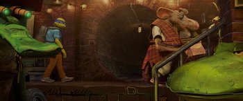 Movie still from “Teenage Mutant Ninja Turtles: Mutant Mayhem” (2023), directed by Jeff Rowe – An image of a man with a mouse on his lap; Wide shot, Low angle