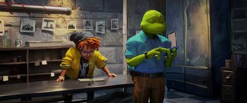 Movie still from “Teenage Mutant Ninja Turtles: Mutant Mayhem” (2023), directed by Jeff Rowe – A man in a yellow jacket is sitting at a table with another man; Medium shot, Over the shoulder angle