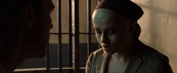 Movie still from “Terminator Salvation” (2009), directed by McG – A woman with a nun's head covering in front of a jail cell; Close Up shot, Over the shoulder angle