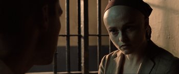 Movie still from “Terminator Salvation” (2009), directed by McG – A person with a bald head in front of a jail cell; Close Up shot, Over the shoulder angle