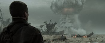 Movie still from “Terminator Salvation” (2009), directed by McG – A man standing in a field near a large pile of debris; Close Up shot, Over the shoulder angle