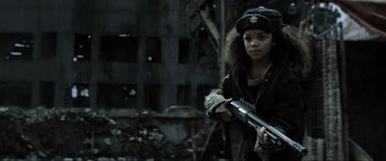 Movie still from “Terminator Salvation” (2009), directed by McG – A young girl is holding a gun in a dark place; Close Up shot, Over the shoulder angle