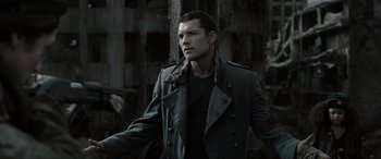 Movie still from “Terminator Salvation” (2009), directed by McG – A man in a trench coat standing next to a tree; Close Up shot, Over the shoulder angle