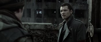 Movie still from “Terminator Salvation” (2009), directed by McG – A man standing in front of an old building; Close Up shot, Over the shoulder angle
