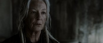 Movie still from “Terminator Salvation” (2009), directed by McG – An older woman with long white hair looking at the camera; Close Up shot, Low angle