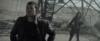 Movie still from “Terminator Salvation” (2009), directed by McG – A man standing in the dirt near a pile of rubble; Close Up shot, Over the shoulder angle
