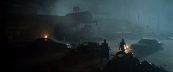 Movie still from “Terminator Salvation” (2009), directed by McG – Two men are walking in the rain near a fire hydrant; Extreme Wide shot, Low angle