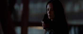 Movie still from “Terminator Salvation” (2009), directed by McG – A woman holding a gun in a dark room; Close Up shot, Low angle