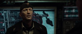Movie still from “Terminator Salvation” (2009), directed by McG – A man in a military uniform standing in front of a map; Close Up shot, Over the shoulder angle