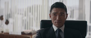 Movie still from “Tetris” (2023), directed by Jon S. Baird – A person wearing a suit and tie; Close Up shot, Over the shoulder angle