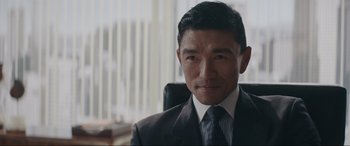 Movie still from “Tetris” (2023), directed by Jon S. Baird – A person wearing a suit and tie; Close Up shot, Over the shoulder angle