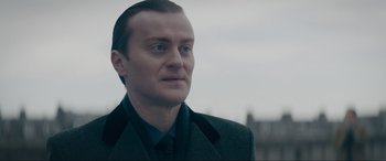 Movie still from “Tetris” (2023), directed by Jon S. Baird – A person wearing a suit and tie; Close Up shot, Over the shoulder angle