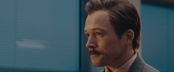 Movie still from “Tetris” (2023), directed by Jon S. Baird – A person wearing a suit and tie; Close Up shot, Over the shoulder angle