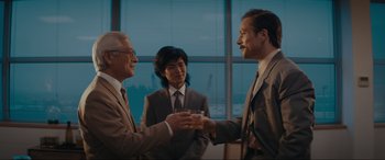 Movie still from “Tetris” (2023), directed by Jon S. Baird – A group of men in suits and ties holding drinks; Medium shot, Low angle