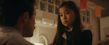 Movie still from “Tetris” (2023), directed by Jon S. Baird – A young girl is looking at a man in a room; Close Up shot, Over the shoulder angle