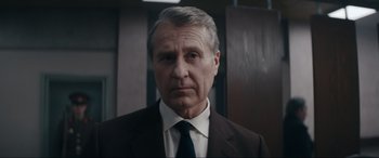 Movie still from “Tetris” (2023), directed by Jon S. Baird – An older man wearing a suit and tie; Close Up shot, Low angle