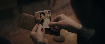 Movie still from “Tetris” (2023), directed by Jon S. Baird – A person is holding a picture of a woman; Extreme Close Up shot, Over the shoulder angle