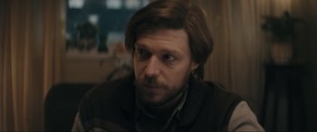 Movie still from “Tetris” (2023), directed by Jon S. Baird – A person wearing a sweater; Close Up shot, Over the shoulder angle