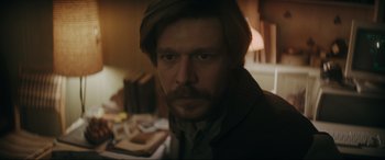 Movie still from “Tetris” (2023), directed by Jon S. Baird – A person wearing a suit and tie; Close Up shot, Over the shoulder angle