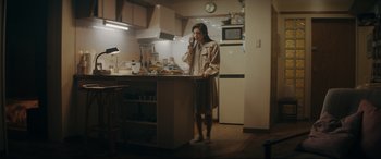 Movie still from “Tetris” (2023), directed by Jon S. Baird – A woman standing in a kitchen talking on the phone; Wide shot, Low angle