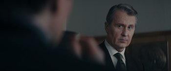 Movie still from “Tetris” (2023), directed by Jon S. Baird – A person wearing a suit and tie; Close Up shot, Over the shoulder angle