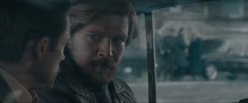 Movie still from “Tetris” (2023), directed by Jon S. Baird – A person with a beard; Close Up shot, Over the shoulder angle