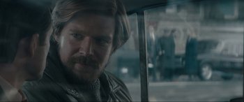 Movie still from “Tetris” (2023), directed by Jon S. Baird – A person with a beard; Close Up shot, Over the shoulder angle