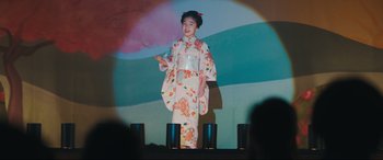 Movie still from “Tetris” (2023), directed by Jon S. Baird – A young girl in a kimono standing on a stage; Medium shot, Low angle