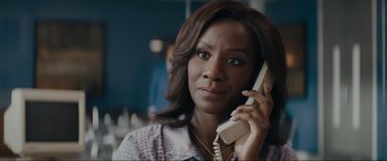 Movie still from “Tetris” (2023), directed by Jon S. Baird – A woman talking on a phone while sitting down; Close Up shot, Over the shoulder angle