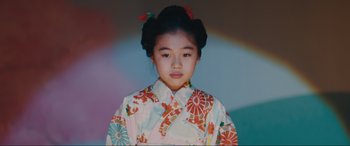 Movie still from “Tetris” (2023), directed by Jon S. Baird – A young asian girl in a colorful kimono; Close Up shot, Low angle