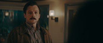 Movie still from “Tetris” (2023), directed by Jon S. Baird – A person with a mustache in a room; Close Up shot, Over the shoulder angle