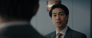 Movie still from “Tetris” (2023), directed by Jon S. Baird – A man wearing a suit and tie talking to another man wearing a suit and tie; Close Up shot, Over the shoulder angle
