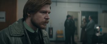 Movie still from “Tetris” (2023), directed by Jon S. Baird – A person with a beard in a room; Close Up shot, Over the shoulder angle