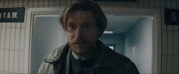 Movie still from “Tetris” (2023), directed by Jon S. Baird – A person with a beard; Close Up shot, Over the shoulder angle