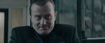 Movie still from “Tetris” (2023), directed by Jon S. Baird – A person wearing a suit and tie; Close Up shot, Low angle