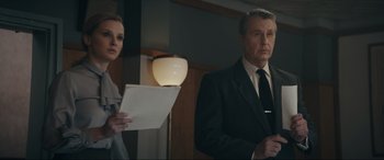 Movie still from “Tetris” (2023), directed by Jon S. Baird – A man and a woman standing next to each other in a room; Medium shot, Low angle