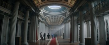 Movie still from “Tetris” (2023), directed by Jon S. Baird – A group of people standing inside of a large building; Extreme Wide shot, Low angle