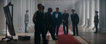 Movie still from “Tetris” (2023), directed by Jon S. Baird – A group of men standing on top of a red carpet; Wide shot, Low angle