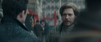 Movie still from “Tetris” (2023), directed by Jon S. Baird – A man with a beard is standing in the street; Close Up shot, Over the shoulder angle