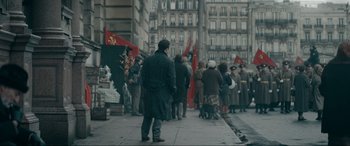Movie still from “Tetris” (2023), directed by Jon S. Baird – A group of people walking down a street; Wide shot, Over the shoulder angle