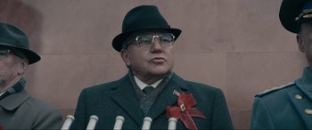 Movie still from “Tetris” (2023), directed by Jon S. Baird – An older man wearing a suit and a hat; Close Up shot, Low angle