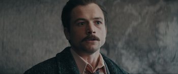 Movie still from “Tetris” (2023), directed by Jon S. Baird – A person with a mustache wearing a tie; Close Up shot, Low angle